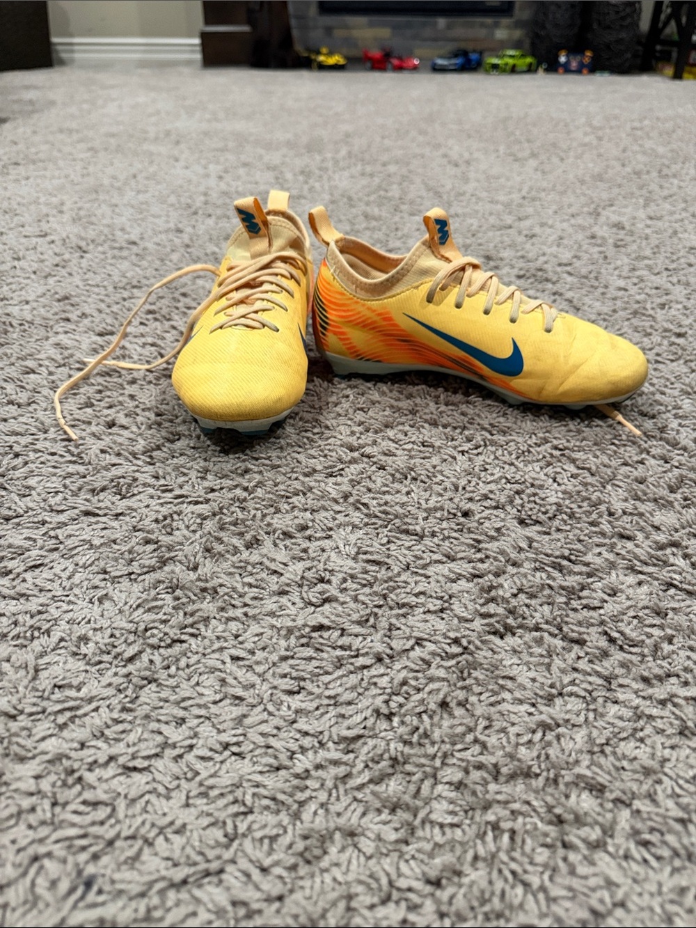 Nike Yellow Soccer Cleats with Blue Swoosh and Orange Accents